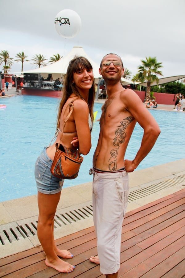 a girl in swimsuit and jeans and a man in white trousers are standing next to a swimming pool reprezentive photography work of a music festival in barcelona