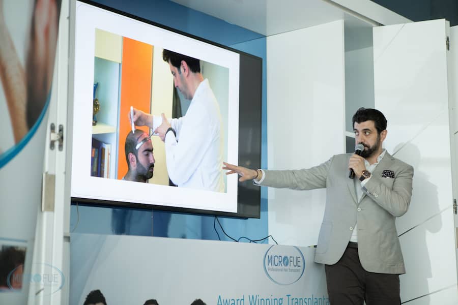 Conference speaker on the stage pointing at tv screen