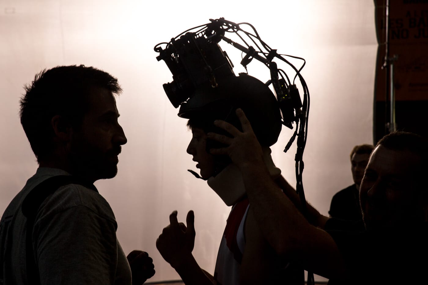 Film production crew member installing helmet camera on basketball player