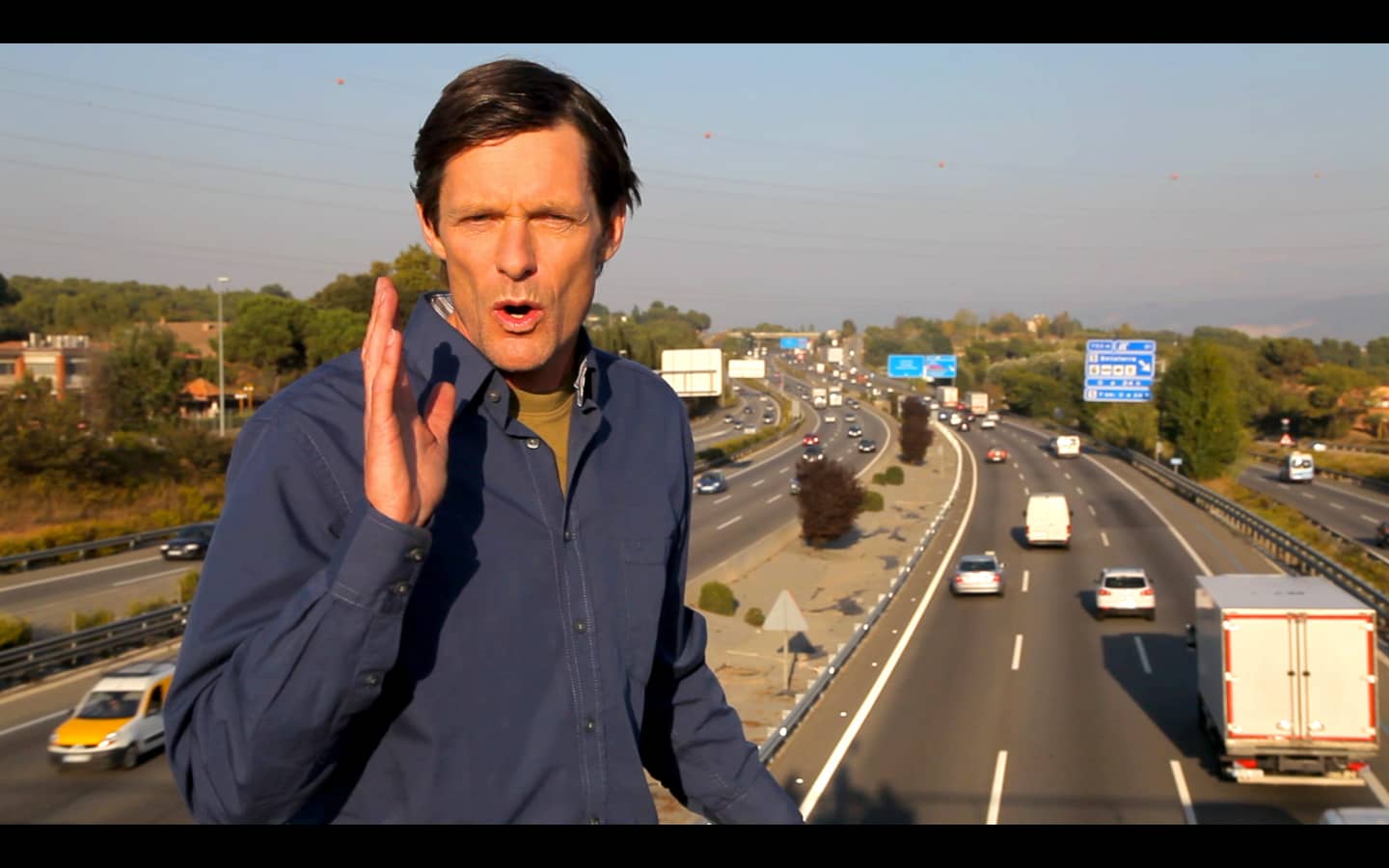 man talking to the camera above the highway, from a video advertisement