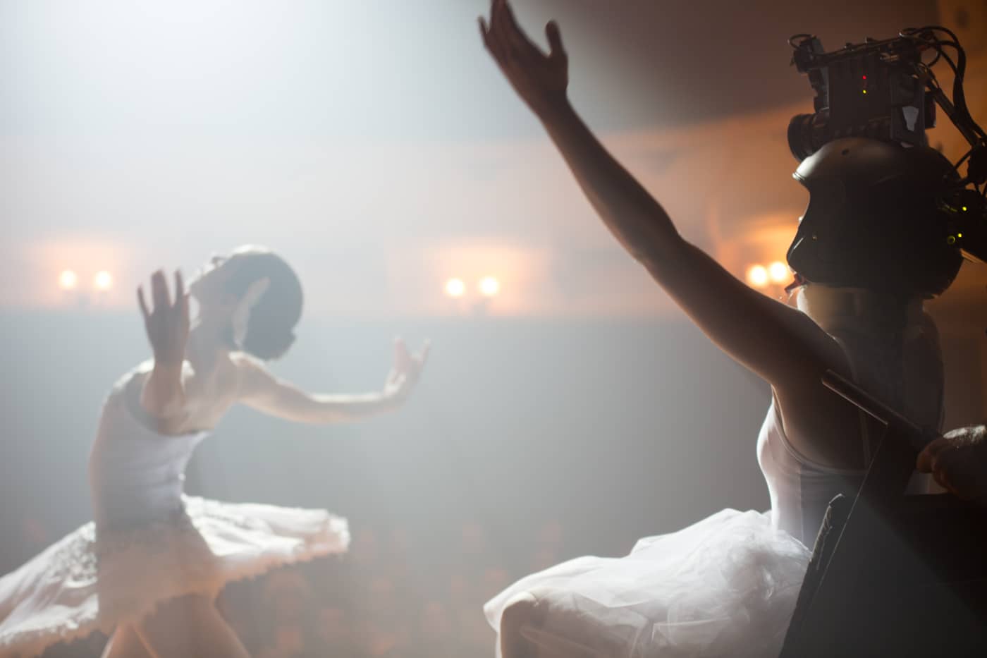 Side view shot of ballerinas dancing on stage with soft lights