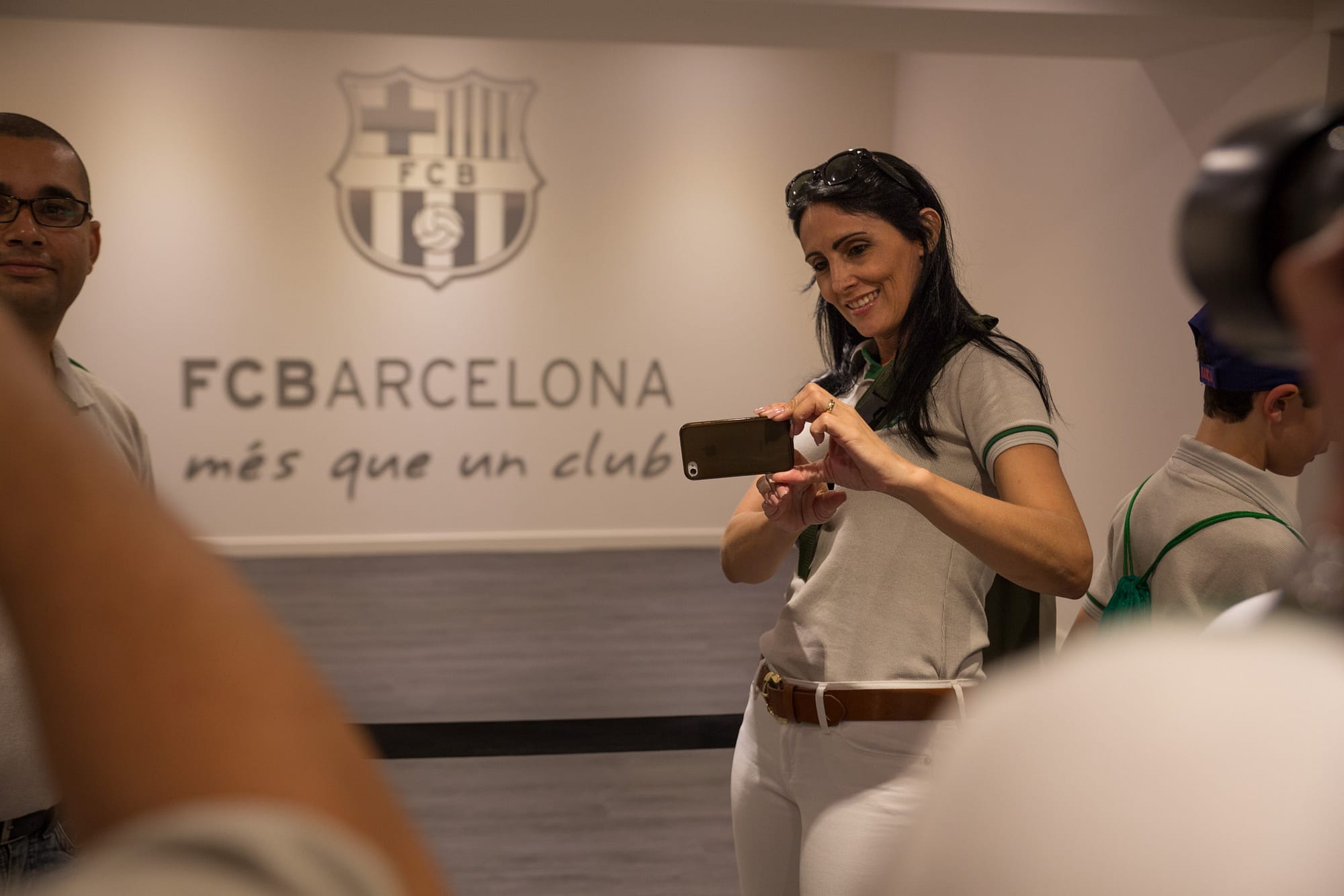 black haired woman is taking a photo with her phone captured by an event photographer barcelona