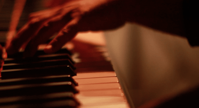 Hands playing piano keyboard