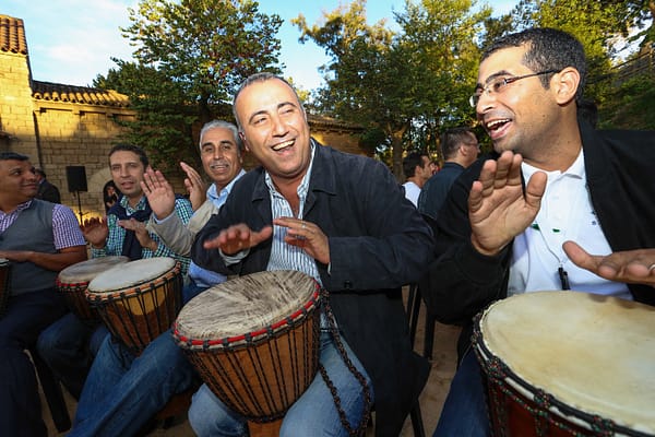Los hombres están jugando en un tambor tradicional