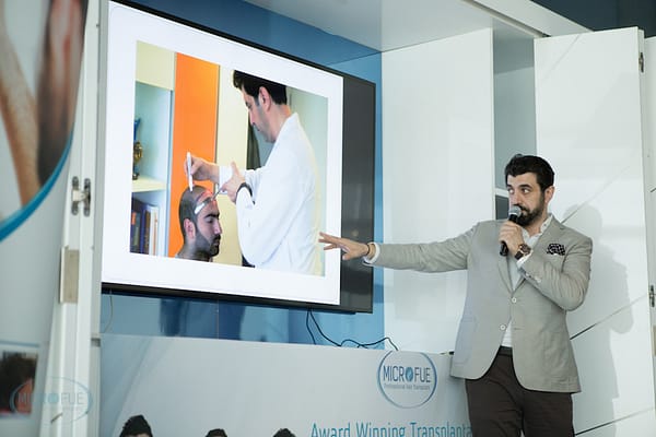 Conference speaker on the stage pointing at tv screen
